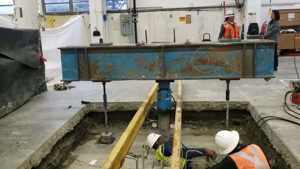 Steel beam and workers at a foundation opening inside the building
